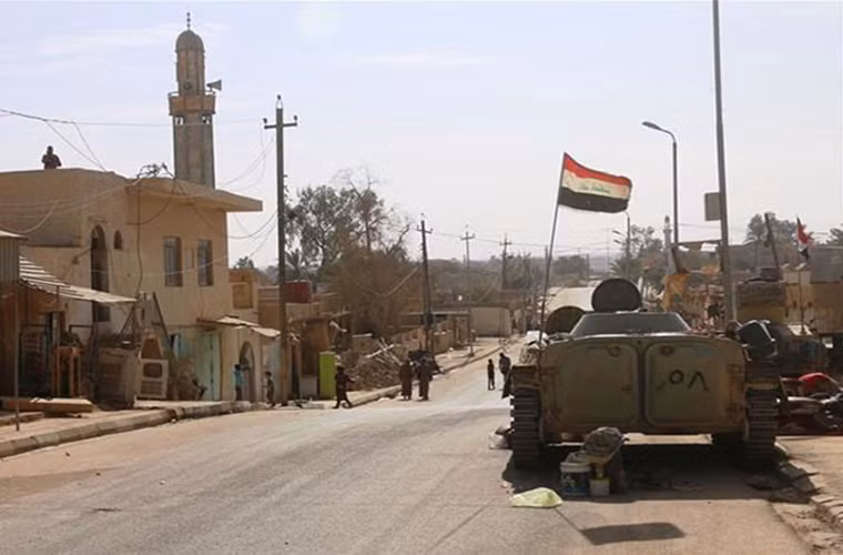 Lá cờ Iraq tung bay trên đường phố Rawa sạch bóng phiến quân IS. Ảnh: FNA.