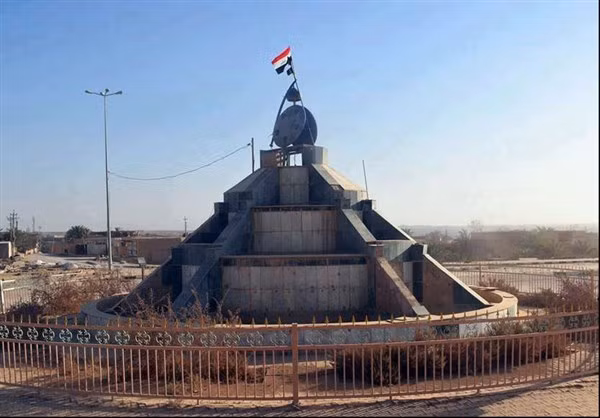 Lực lượng Iraq cắm cờ tại một tượng đài ở Rawa. Ảnh: FNA.