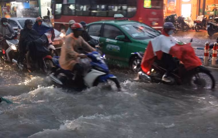 Người dân bì bõm lội nước về nhà trong cơn mưa như trút nước kéo dài hơn 2 tiếng đồng hồ.