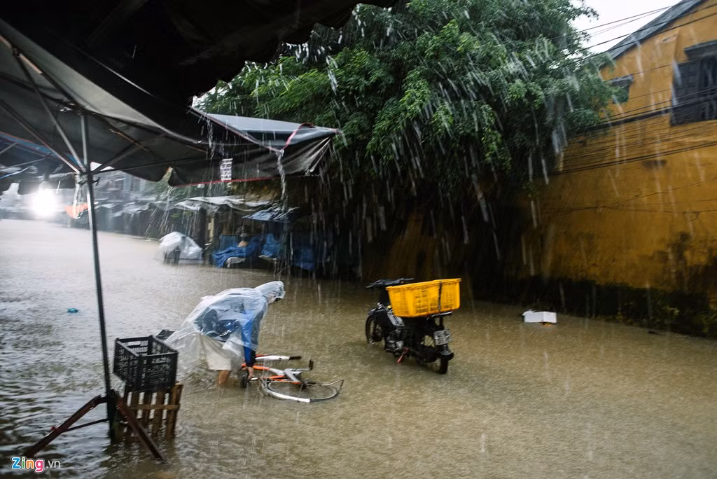 Mưa lớn liên tục trút xuống kèm theo gió mạnh, người đi xe đạp khó giữ vững tay lái.