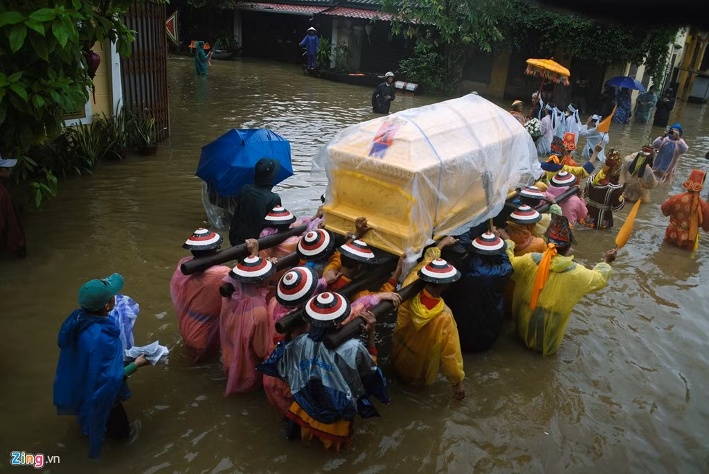 Do nước ngập sâu có đoạn hơn nửa mét nên những người khênh linh cữu khá vất vả. Để đảm bảo không bị ướt, áo quan được phủ nilon, cả đoàn đi chậm, lò dò nặng nề dưới áp lực của nước.