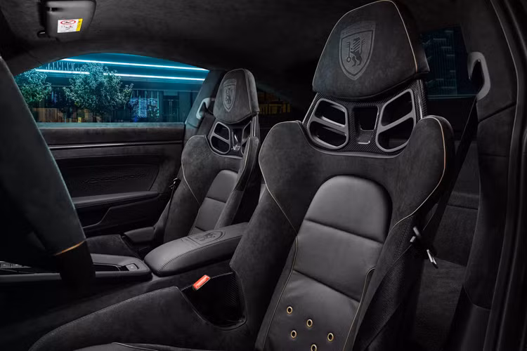 Sợi carbon cũng được tìm thấy trong chắn bùn mới, có lỗ thoát nhiệt giống như trên GT3 RS. Bên trong, cabin xe được bọc lại hoàn toàn bằng da Alcantara, dây buộc bằng da và các mảng miếng sợi carbon. Điều này áp dụng cho mọi thứ, từ bảng điều khiển đến thẻ cửa, từ ghế ngồi đến thảm sàn.