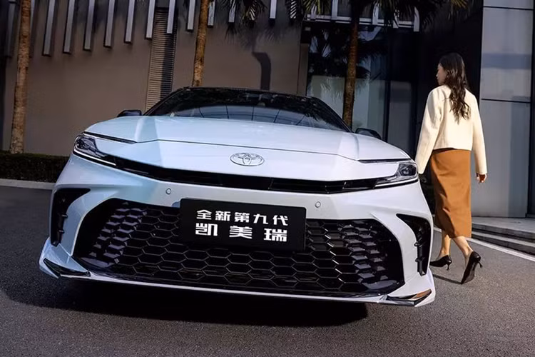 Với Toyota Camry 2024 bản Sport, xe sẽ được trang bị bộ lưới tản nhiệt cỡ lớn có dạng lưới tổ ong sơn đen, 2 khe gió nằm dọc cũng được sơn màu đen và tích hợp đèn sương mù hình tròn. Trong khi đó bản Luxury sẽ có lưới tản nhiệt hẹp hơn với lưới mắt cáo sơn cùng màu thân xe, khe gió ở hai góc đầu xe hẹp hơn so với phong cách Sport.