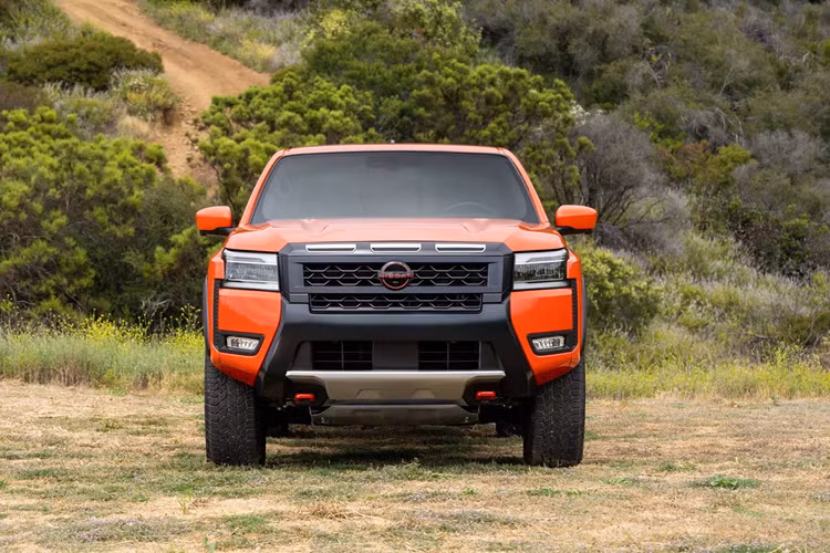 Ở khía cạnh ngoại hình, Nissan Frontier 2025 thể hiện sự khác biệt so với đời trước khi có lưới tản nhiệt dày dặn hơn và không còn dòng chữ tên xe tại nắp ca-pô nữa. Toàn bộ các cụm khe hút gió phía trên và phía dưới được kết nối thành một thể thống nhất, đồng thời cũng có thêm đường trang trí nối đèn chiếu sáng chính với đèn sương mù.