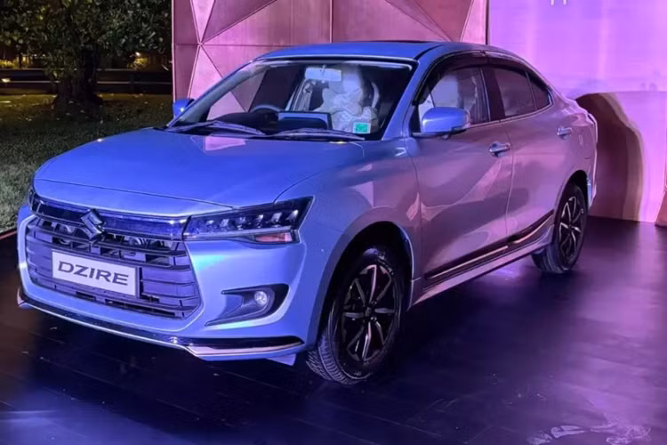 Nối giữa 2 cụm đèn pha là nẹp màu đen bóng dày dặn, tích hợp logo của hãng Suzuki. Lưới tản nhiệt của Suzuki Dzire 2025 có thiết kế hình lục giác cỡ lớn với 6 nan nằm ngang màu đen. Ở hai góc đầu xe là đèn sương mù hình tròn với viền màu đen bao quanh. Bản cao cấp của xe sẽ được trang bị hệ thống đèn LED phía trước.