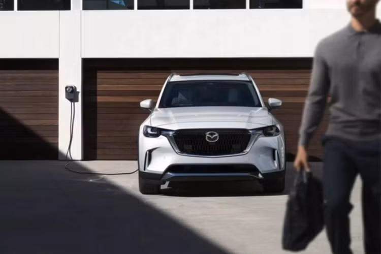 Mẫu xe SUV Mazda CX-90 Premium Sport nổi bật với lưới tản nhiệt màu đen bóng đi cùng các chi tiết mạ crôm và huy hiệu cũng màu đen bóng bẩy. Xe được trang bị bộ mâm hợp kim đen có kích thước 21 inch khỏe khoắn và gương chiếu hậu màu đen piano.