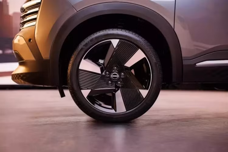 Những chi tiết nằm ngang này khiến khu vực đầu xe của Nissan Kicks 2025 trông rộng và bề thế hơn trước. Tiếp theo đó là cản trước mới với hốc gió trung tâm tích hợp hộp chứa các cảm biến. Vòng sang bên sườn, chúng ta sẽ bắt gặp đường gân thẳng thớm, kéo dài từ đèn pha đến đèn hậu.