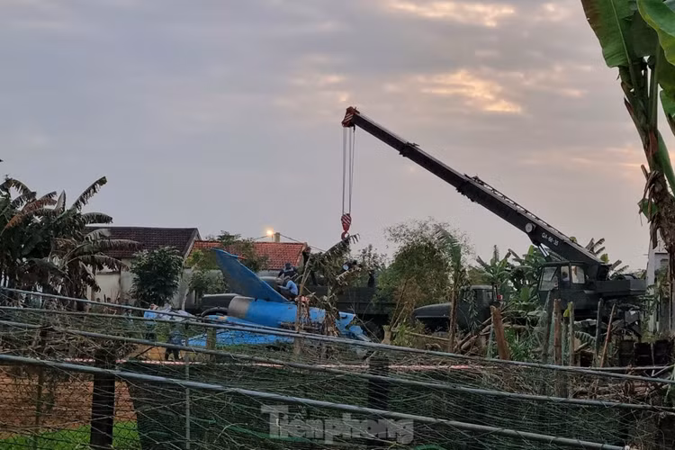 Khi phi công báo máy bay gặp sự cố, không thể về hạ cánh được, chỉ huy bay lệnh cho phi công cố gắng đưa máy bay ra khỏi khu đông dân cư và nhảy dù. Đại úy phi công Đỗ Tiến Đức đã nỗ lực đưa máy bay ra xa khu dân cư và nhảy dù an toàn. Trong ảnh: Phần đuôi máy bay nằm ngay khoảng đất trống, xung quanh là nhà dân. (Ảnh: Thanh Trần).