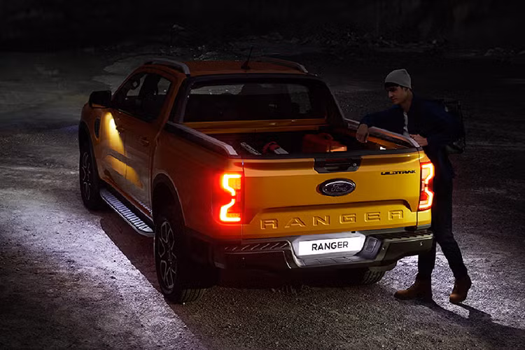 Ford Ranger Wildtrak V6 2024 tại Thái Lan có gương bên chỉnh điện, đèn chiếu sàn đón người dùng, ổ điện tại cửa hậu hay bậc chân tích hợp vào hông xe để người dùng trèo lên/xuống bồn sau dễ dàng.