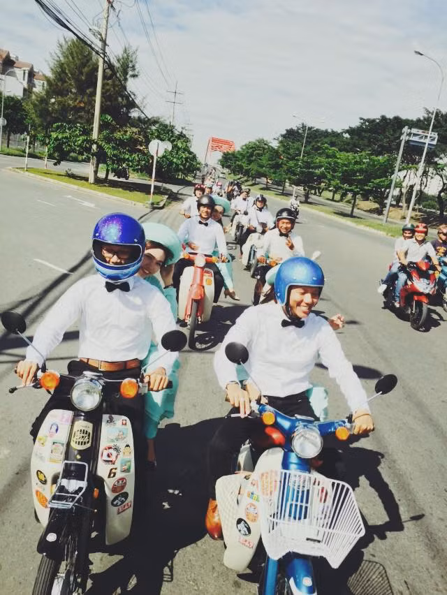 Đoàn rước dâu bao gồm 10 chiếc xe Cub đi thành hàng và những người điều khiển xe đều đội mũ bảo hiểm đầy đủ.
