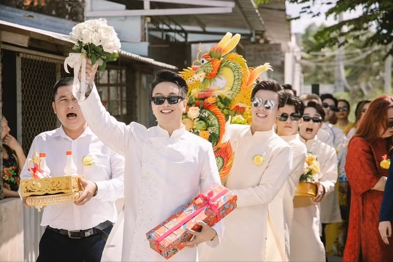 Thành viên nhóm nhạc HKT dẫn đầu đoàn nhà trai mang theo sinh lễ. Ảnh: Znews.