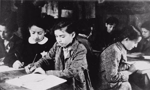 Các em nhỏ ngồi học trong một ngôi trường bí mật ở khu ổ chuột Kovno.