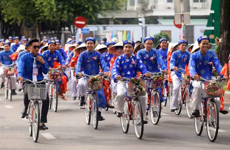 Các cặp đôi trong trang phục cô dâu chú rể truyền thống chở nhau trên xe đạp diễu hành qua các tuyến đường ở trung tâm TP.