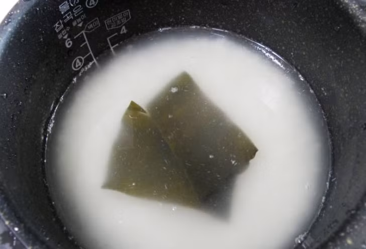 Nấu cơm. Bí quyết nấu cơm để cuốn Kimbap ngon của người Hàn chính là cho 2 miếng tảo bẹ vào nồi tạo mùi thơm tự nhiên cho cơm.
