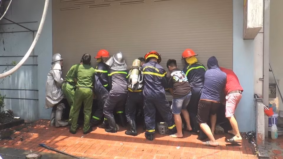 Ngọn lửa có dấu hiệu lan sang ngôi nhà 4 tầng bên cạnh quán bia. Lực lượng chức năng phối hợp cùng người dân cậy cửa ở ngôi nhà này để khống chế ngọn lửa. 
