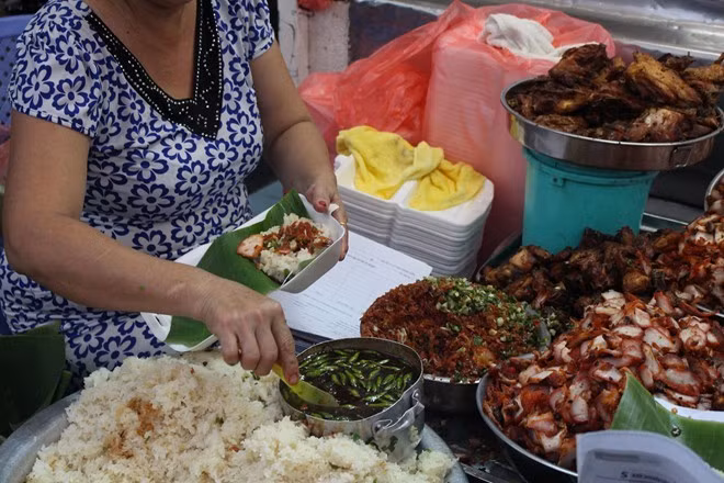 Xôi Gà Bà Chiểu nức tiếng là một gánh xôi nằm trên đường Nguyễn Hữu Nghĩa phía sau chợ. Xôi ở đây ngoài được đánh giá cao về độ dẻo của nếp, thì hương thơm của món gà chiên giòn hay xá xíu chính là điều tạo nên tên tuổi của quán. Ảnh: Huỳnh Hằng.