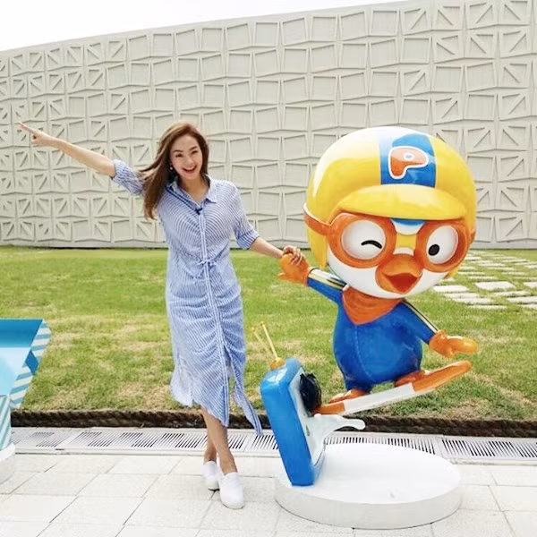 Minh Hằng trẻ trung với đầm sơmi kẻ tăm gam xanh tạo dáng nghịch ngợm trong chuyến công tác nước ngoài.