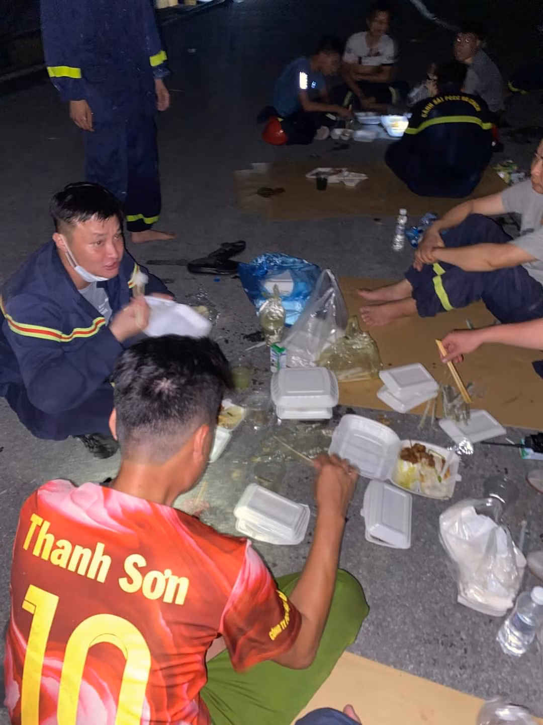Sau một ngày căng mình chữa cháy, các chiến sĩ cảnh sát PCCC của công an TP Hải Phòng ăn vội suất cơm hộp ngay tại hiện trường. Ảnh: CTV
