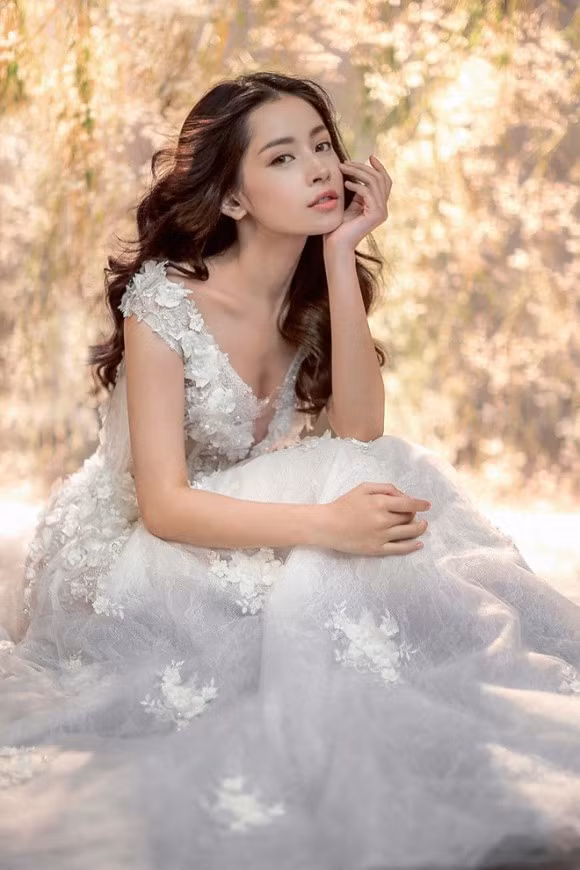 Váy cưới kết hợp cùng phom dáng váy dạ hội mang lại vẻ kiêu sa, lộng lẫy cho cô dâu trong ngày cưới. Trong ảnh, gương mặt diễn viên Vẫn có em bên đời được trang điểm màu nude, phù hợp tổng thể trang phục trắng.