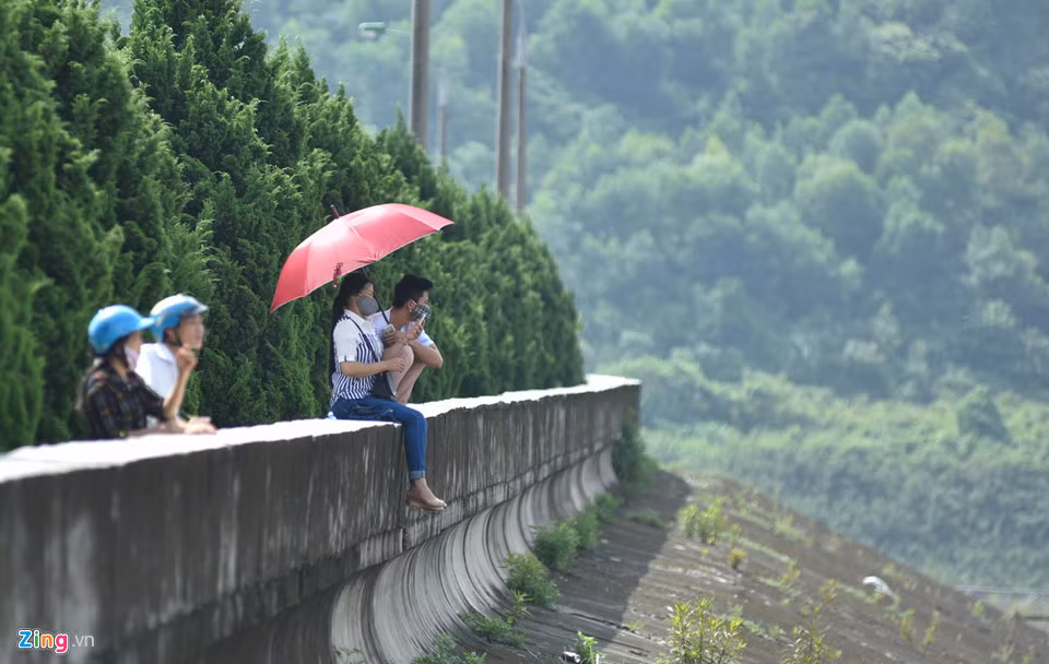 Ở một góc khác, du khách còn trèo lên cả thành đập, vắt chân ra ngoài.