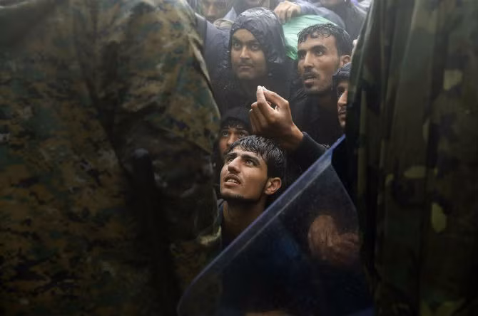 Di dân và người tị nạn cầu xin cảnh sát Macedonia cho phép họ qua biên giới vào nước này trong đợt bão tuyết gần làng Idomeni, Hy Lạp, ngày 10/9/2015.
