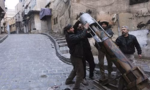 Các chiến binh nổi dậy chuẩn bị bệ phóng tên lửa tự chế trên đường phố Aleppo.