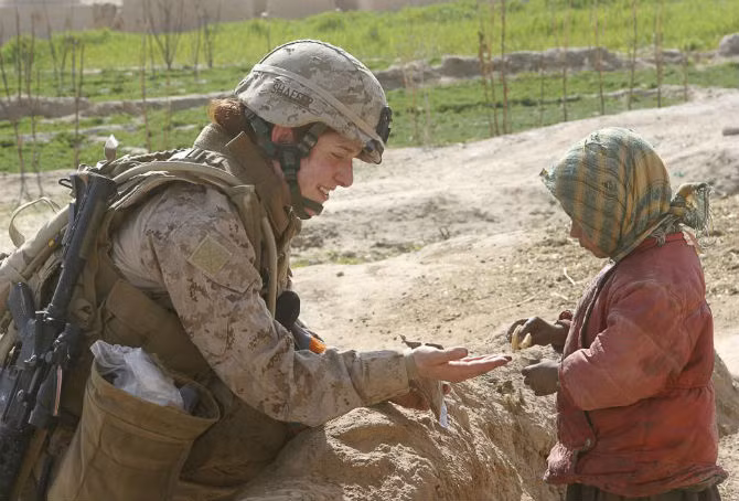 Nữ quân nhân Johanna Shaffer cho em nhỏ Afghanistan một chiếc bánh trong thời gian làm nhiệm vụ ở tỉnh Farad ngày 9/2/2009.