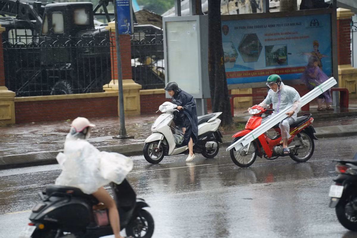 Xe máy di chuyển vất vả trong thời tiết bất ổn.