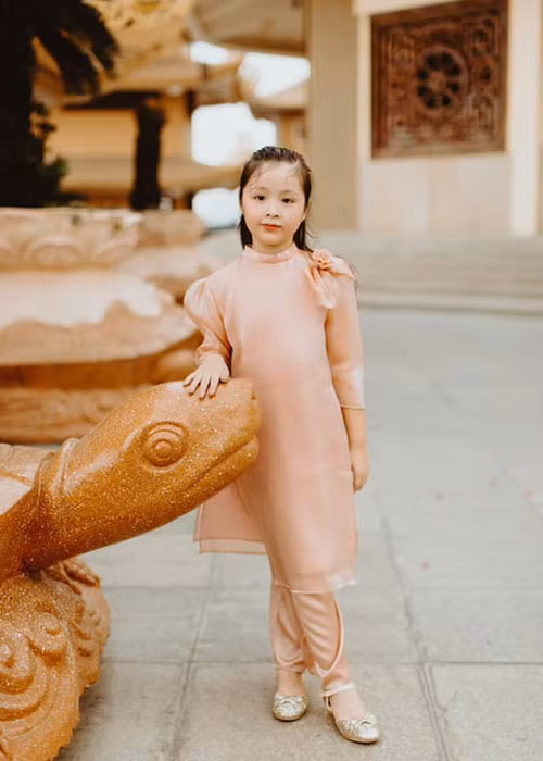 Cô nhóc tự tin tạo dáng trong trang phục áo dài.