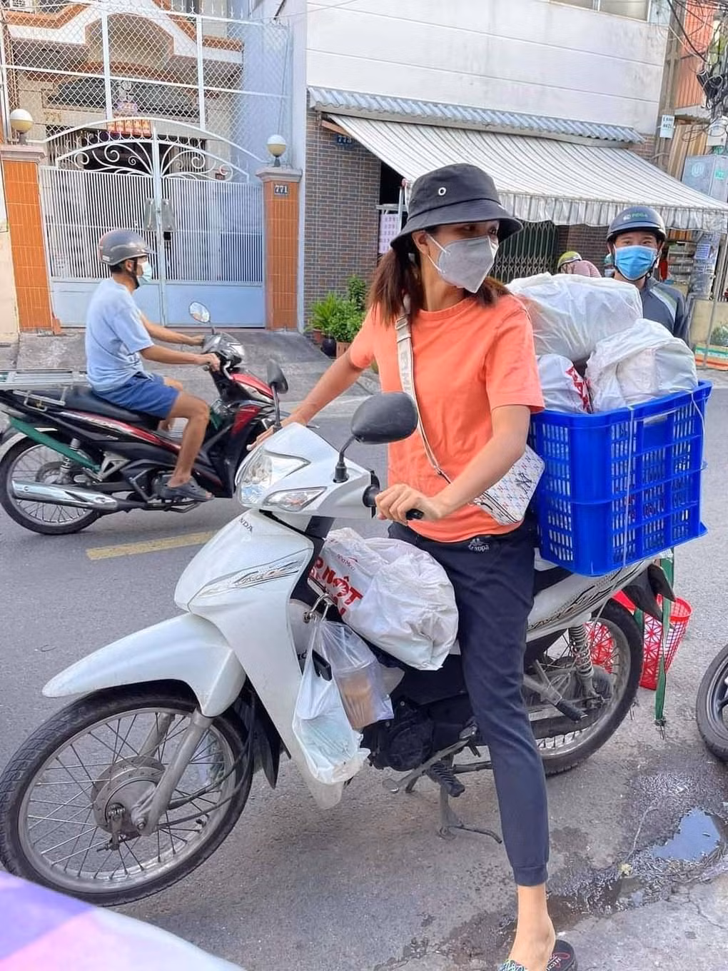 Với trang phục giản dị Hoa hậu H'Hen Niê chạy xe máy để đi giao đồ cho người dân khu cách ly.