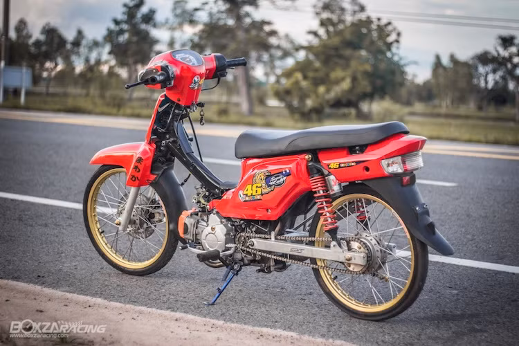 Dù có lốp mỏng nhưng do sử dụng loại lốp Michelin City Grip nên độ bám đường của chiếc Dream Super Cub vẫn khá ổn định. Để khiến chiếc xe nhẹ và ít cản gió hơn, chủ của chiếc Dream Super Cub này đã tháo bỏ hoàn boàn bộ yếm trước và nhựa ốp lườn của chiếc xe. Bên cạnh đó, yên xe nguyên bản cũng đã được gọt mỏng lại.