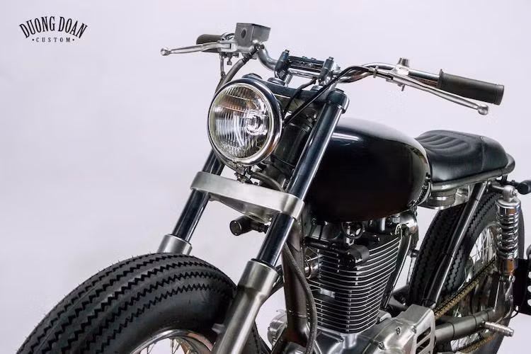 "Dàn đầu" nguyên bản với kiểu dáng cổ điển của Savage 400 đã được DuongDoan Design giữ nguyên trên bản độ mới nhất này. Trong khi đó, bánh trước của chiếc xe đã được giảm kích thước từ 19 inch nguyên bản. Tay lái dạng tracker đem tới cho chiếc xe vẻ đẹp phóng khoáng và đậm chất brat hơn.