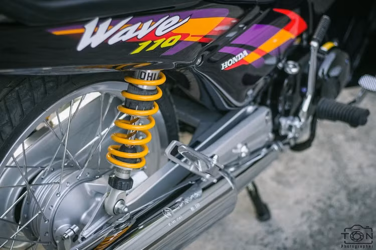 Nằm ở phía sau xe là cặp phuộc Ohlins với núm chỉnh độ nén lò xo. Cùng với cặp lốp Michelin City Grip cho cả 2 bánh, độ ổn định và linh hoạt của chiếc Wave đã được cải thiện.