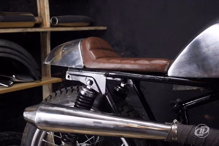 Một chiếc cafe racer không thể thiếu được đuôi gò khí động học, và xưởng độ Hà Nội đã tạo ra chi tiết này bằng cách gò nhôm tương tự bình xăng. Bộ yên dành cho một người cũng có thiết kế tối giản và được bọc da màu nâu cổ điển.