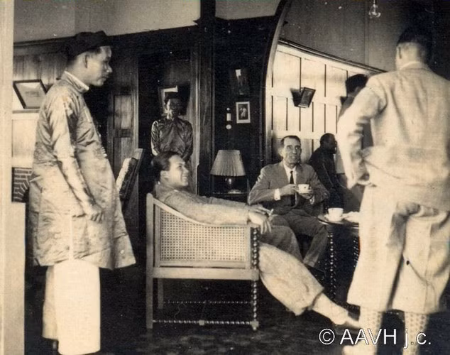 Vua Bảo Đại ngồi trên ghế bành bên cạnh Léon Sogny - người phụ trách an ninh ở CATECKA, khi trò chuyện với ông Choisnel.