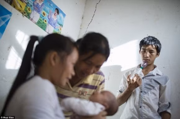 Xiao Ming 17 tuổi đang cầm máy hút sữa trong khi mẹ và người vợ 16 tuổi bế cậu con trai đầu lòng.