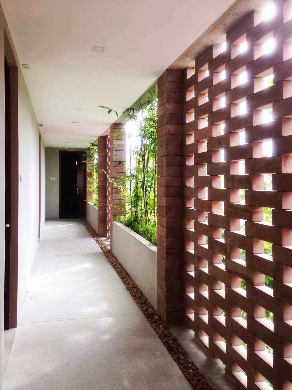 Hành lang khách sạn thoáng đạt và trong lành với hệ thống cây xanh.