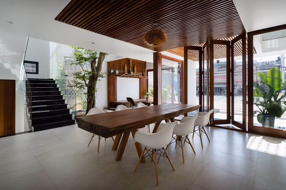 Ngôi nhà trông rất thông thoáng và hài hòa nhờ việc bố trí cây xanh và giếng trời giữa các khu chức năng.