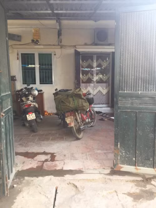 Mặt ngoài của ngôi nhà cấp 4 được che chắn bởi chiếc cổng sắt đã hoen gỉ.