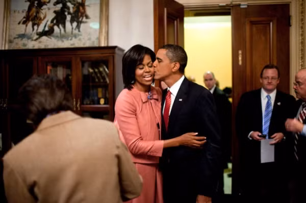 Ông Obama hôn lên má vợ.
