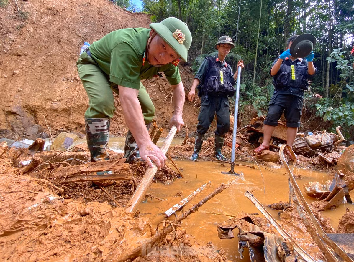 Lực lượng công an liên tục dùng xẻng, cuốc đào bớt lớp đất đá vùi lên xe khách.