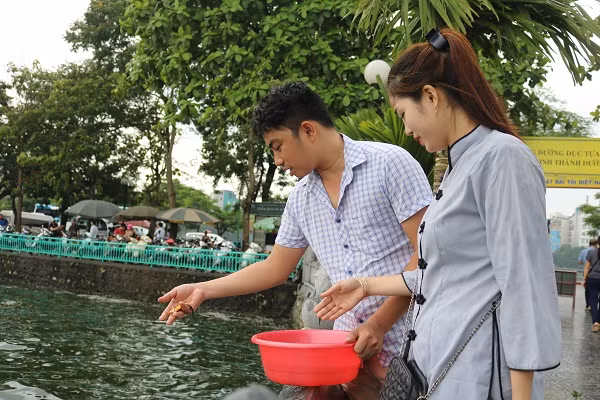 Sau khi làm lễ, người dân đem cá đi phóng sinh