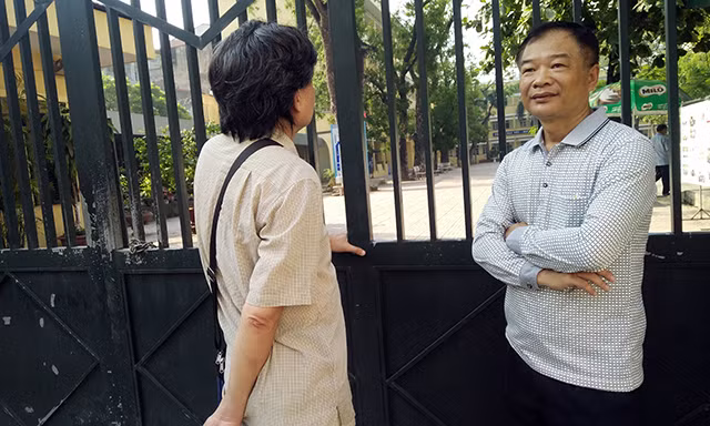 Ông Dũng (phải) và ông Công (trái), phụ huynh của hai thí sinh tại điểm THPT Yên Hòa, đợi con trước cổng trường. Cả hai phụ huynh chia sẻ, với lực học của con em mình cháu có thể tự tin làm bài. Tuy nhiên, trường hợp nếu không đỗ vào trường công, vẫn có thể đưa cháu vào học trường tư.