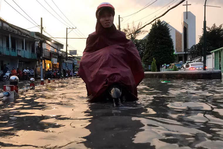 Nước mưa lút cả bánh xe máy khiến người dân một phen khốn đốn trên đường về nhà sau ngày làm việc.