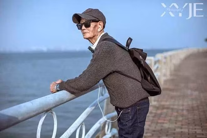 Cụ ông diện quần jeans, kính râm, mũ lưỡi trai, khoác balo như một thanh niên thời thượng.