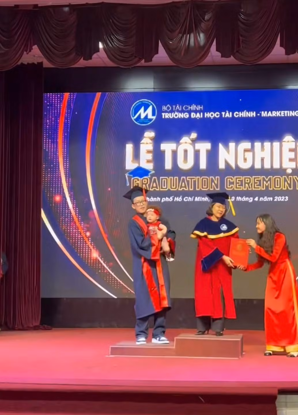 Trong không khí trang trọng của buổi lễ tốt nghiệp, khác với những cử nhân khác, nam sinh này lại một tay bế con lên sân khấu để nhận tấm bằng danh giá.
