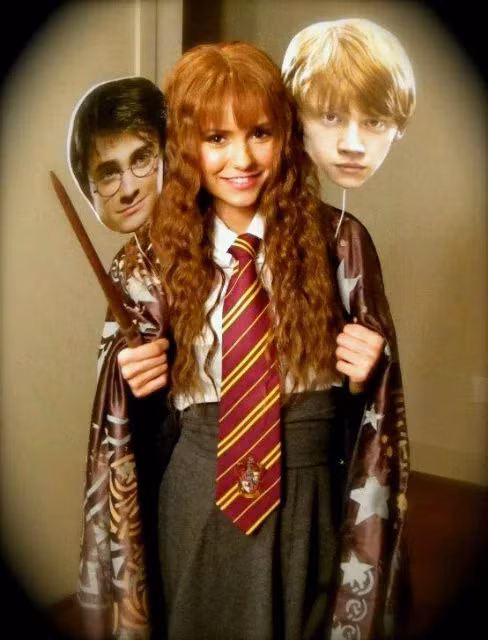 Nina Dobrev phục trang y hệt cô phù thủy nhỏ Hermione Granger, tay còn cầm hai chiếc mặt nạ hình Harry Potter và Ron Weasley trong lễ hội ma quỷ năm 2011. (Ảnh: Getty Images).