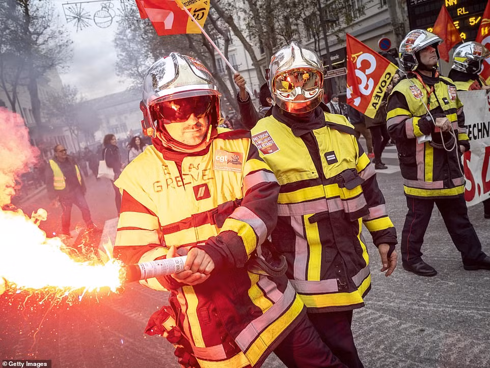 Một người biểu tình ném lựu đạn khói trong cuộc biểu tình gần quảng trường Republique ở trung tâm thủ đô Paris.