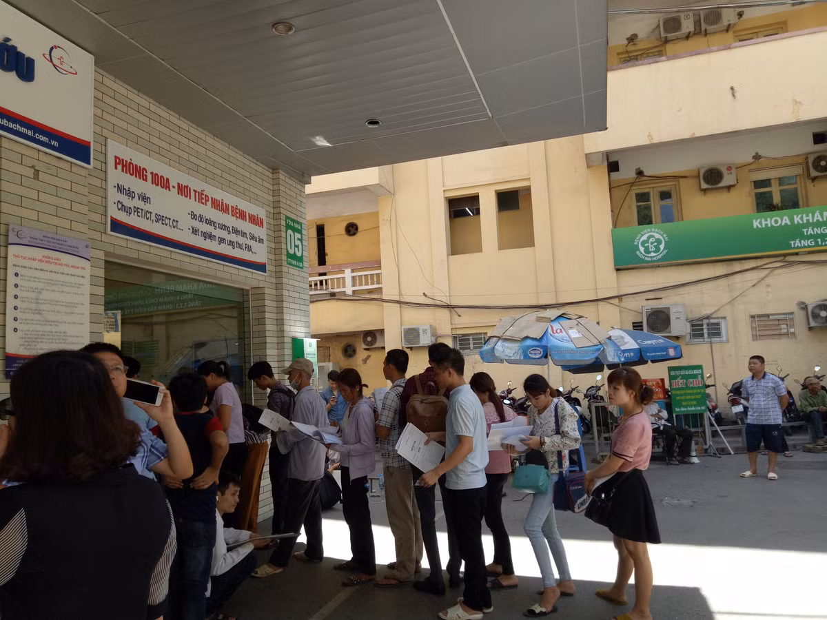 9h sáng, nắng đã bỏng rát, bệnh nhân chỉ dám đứng ở chỗ có mái che, có bóng râm... chờ đến lượt.