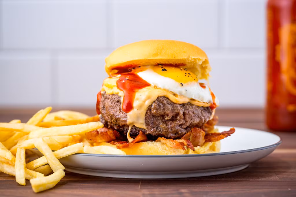  Đồ ăn nhanh Một chiếc bánh mì kẹp thịt thay một suất khoai tây chiên nghe có vẻ là món lý tưởng cho bữa sáng. Tuy nhiên, các món đồ ăn nhanh thường là đồ rán, nhiều mỡ và carb, không chỉ gây hại cho vòng eo của bạn mà còn khiến bạn nhanh đói hơn. Ảnh: Delish.